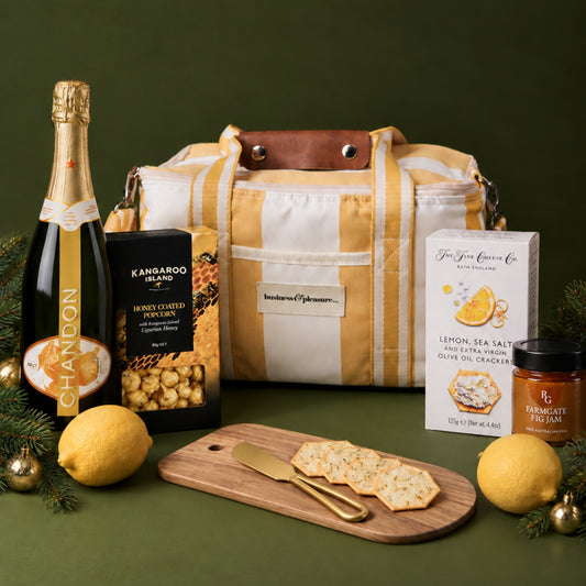 Luxury Christmas picnic hamper with yellow Business & Pleasure cooler bag, Chandon Garden Spritz, cheeseboard and sweet and savoury gourmet treats.